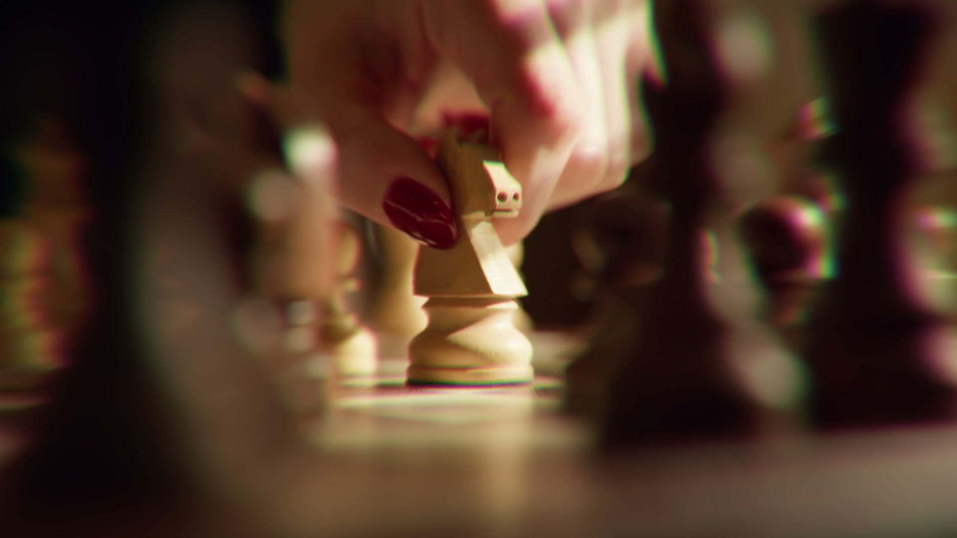 Probe-lens close-up of a hand moving a knight on a chessboard