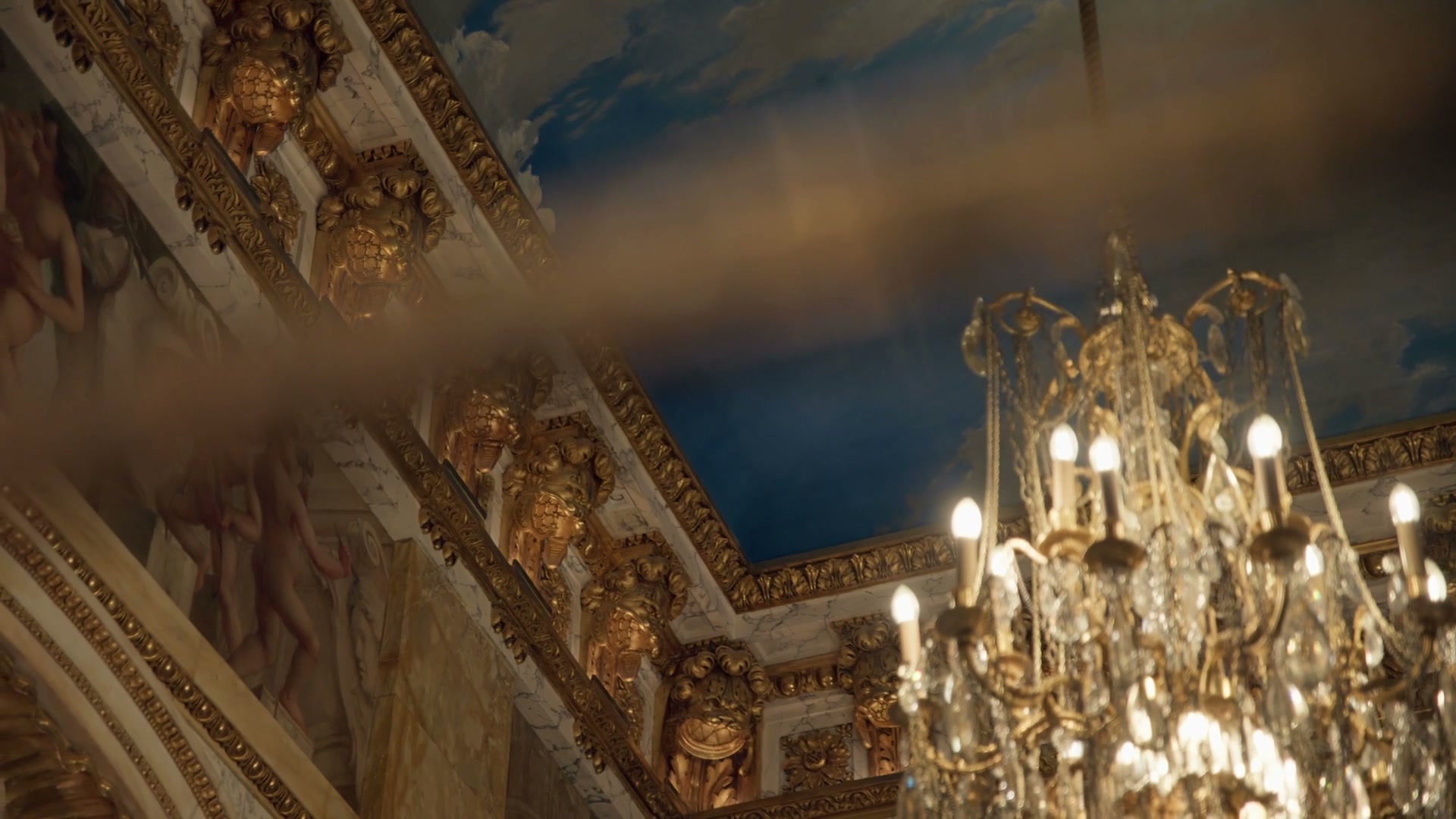 Painted ceiling and crystal chandelier of Hôtel de Crillon in golden light