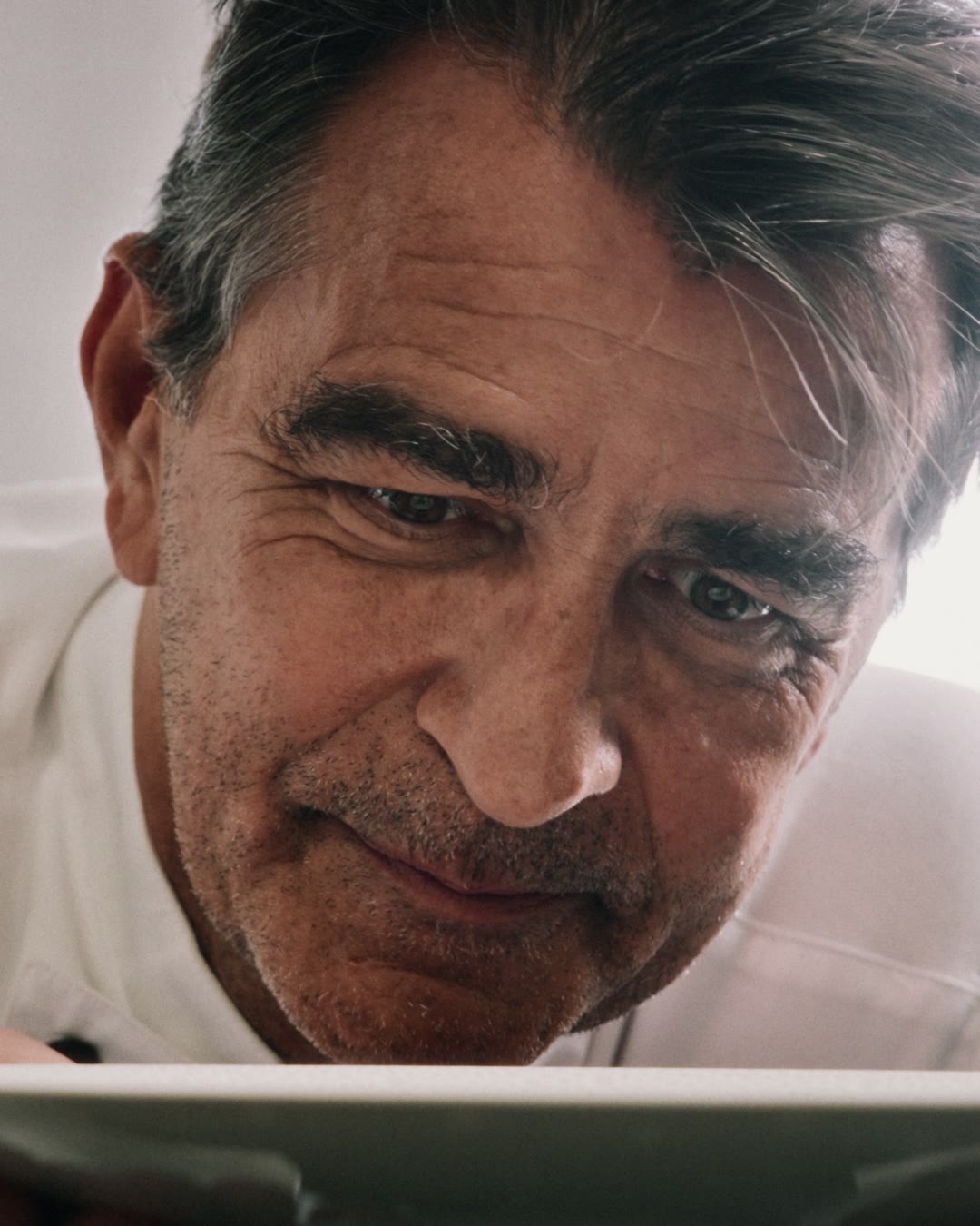 Yannick Alléno leaning over a plate in the kitchen at Hôtel Royal in Evian