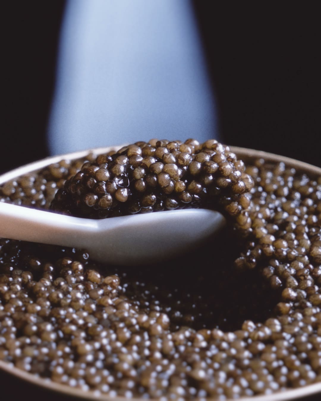 Mother-of-pearl spoon coming out full of Prunier caviar